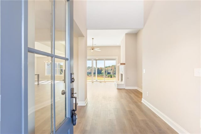 corridor featuring a chandelier and light hardwood / wood-style floors