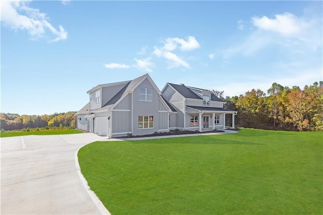 view of front facade featuring covered porch, a garage, and a front lawn