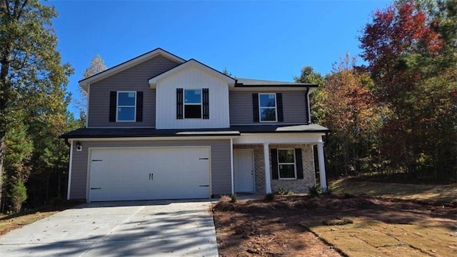 traditional home with an attached garage, driveway, and covered porch