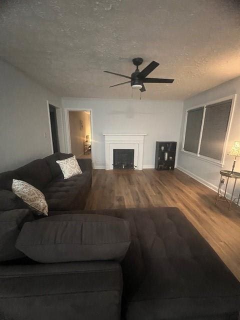 living room with hardwood / wood-style flooring, ceiling fan, and a textured ceiling