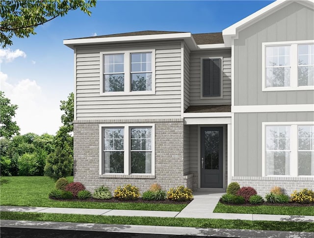 view of front of property featuring a front yard and brick siding