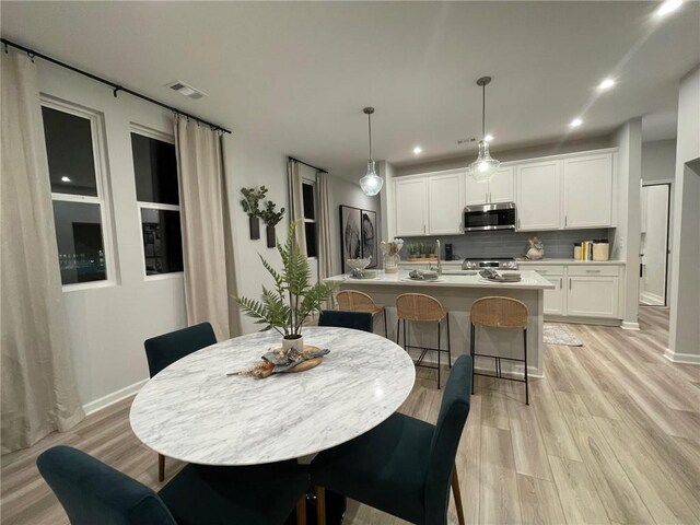 dining area featuring light wood-style flooring, visible vents, baseboards, and recessed lighting