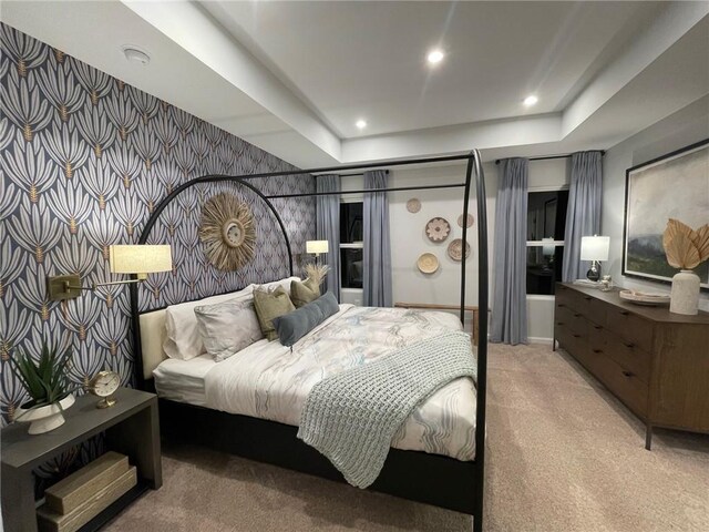 carpeted bedroom with an accent wall, a tray ceiling, recessed lighting, and wallpapered walls