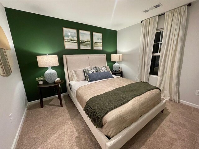 bedroom featuring carpet floors, visible vents, and baseboards