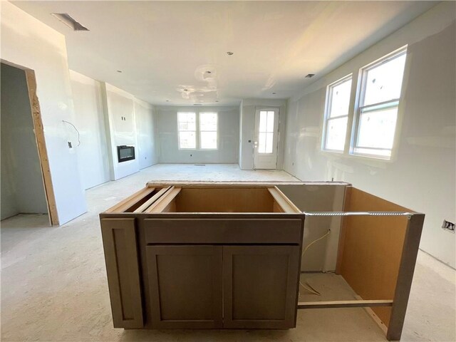 kitchen with open floor plan and a glass covered fireplace