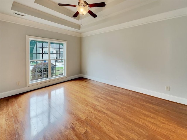 6405 Beaver Creek Trl, Atlanta, GA 30349 - spare room with crown molding, a ceiling fan, baseboards, light wood-type flooring, and a tray ceiling