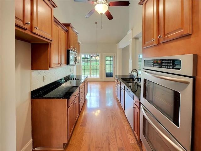 6405 Beaver Creek Trl, Atlanta, GA 30349 - kitchen featuring brown cabinetry, light wood-style floors, black electric stovetop, stainless steel microwave, and a sink