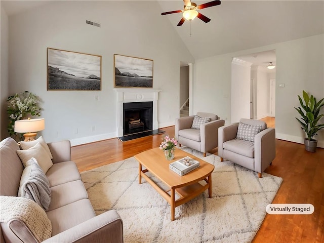6405 Beaver Creek Trl, Atlanta, GA 30349 - living room featuring a ceiling fan, visible vents, wood finished floors, baseboards, and a fireplace with raised hearth