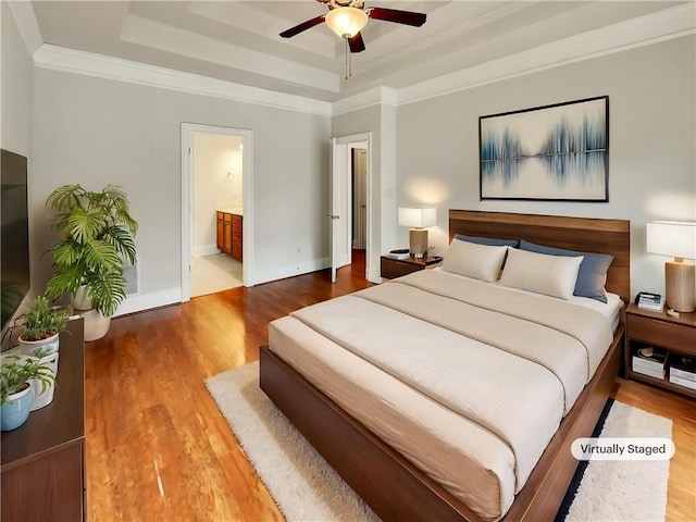6405 Beaver Creek Trl, Atlanta, GA 30349 - bedroom with crown molding, wood finished floors, a raised ceiling, baseboards, and connected bathroom