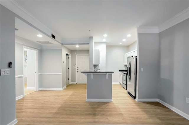 kitchen featuring stainless steel refrigerator, a breakfast bar, white cabinets, and light hardwood / wood-style floors