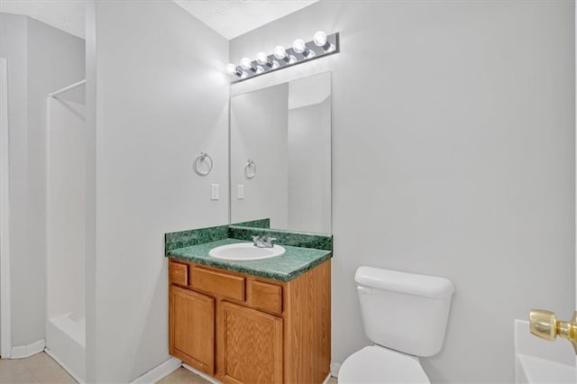 bathroom featuring a shower, vanity, toilet, and baseboards