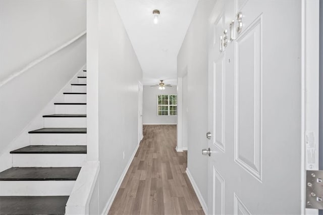 interior space featuring baseboards, stairway, and wood finished floors