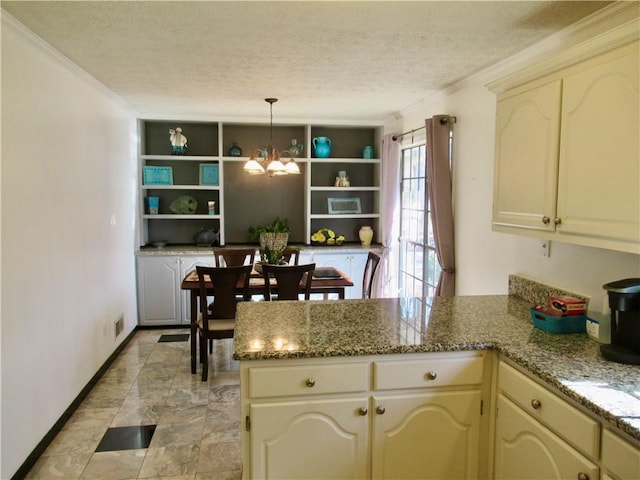 kitchen with a notable chandelier, open shelves, cream cabinets, a textured ceiling, and a peninsula