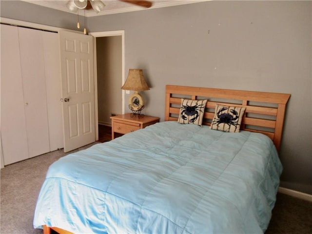 bedroom with ceiling fan, a closet, ornamental molding, and carpet flooring