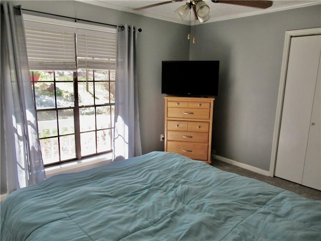 carpeted bedroom with a ceiling fan, crown molding, and baseboards