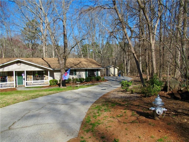 view of front of property featuring an outbuilding, driveway, and a porch