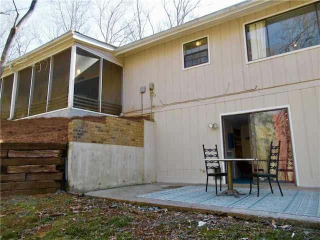 back of house with a sunroom, a patio area, and brick siding