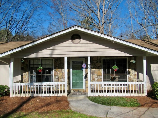 bungalow-style house with covered porch and stone siding