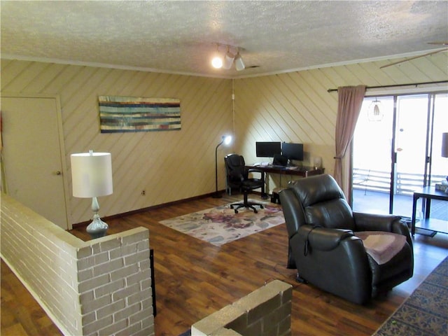 office area with a textured ceiling, ornamental molding, and wood finished floors