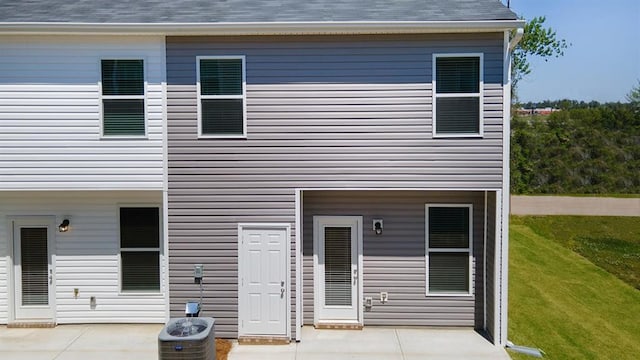 back of house featuring a yard, central AC, and a patio area