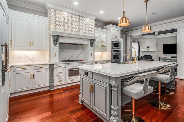 kitchen featuring crown molding, a fireplace, a warming drawer, gray cabinets, and appliances with stainless steel finishes