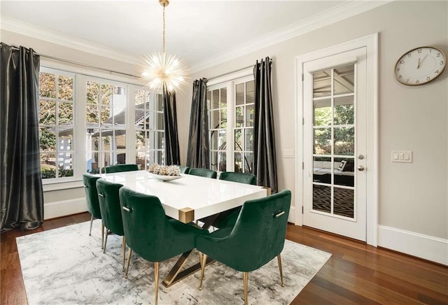 dining area featuring ornamental molding, an inviting chandelier, wood finished floors, and baseboards