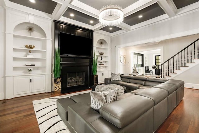 living room with built in shelves, dark wood-style floors, a fireplace, coffered ceiling, and beamed ceiling