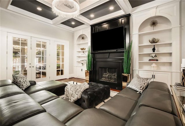 living area featuring a fireplace, coffered ceiling, built in features, french doors, and crown molding