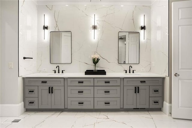 full bath featuring double vanity, marble finish floor, and a sink