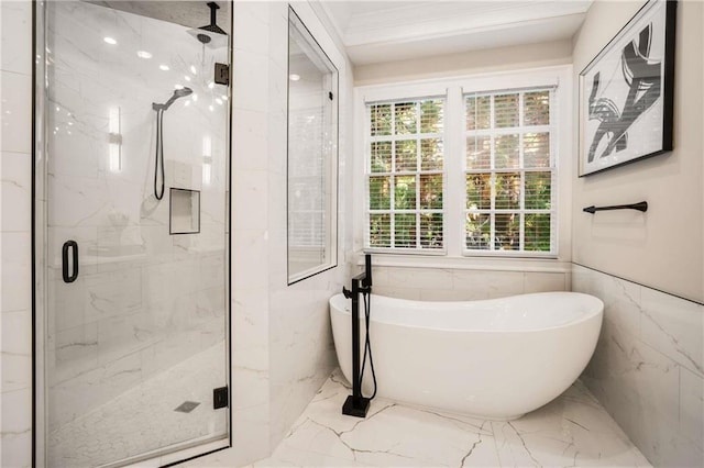 bathroom with a marble finish shower, ornamental molding, marble finish floor, a freestanding tub, and tile walls