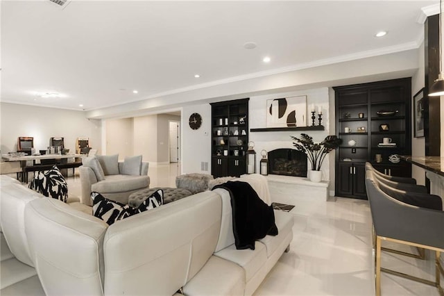 living area with visible vents, ornamental molding, a fireplace with raised hearth, and recessed lighting