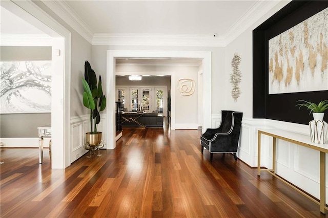 corridor featuring ornamental molding, a wainscoted wall, and wood finished floors