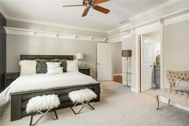 carpeted bedroom featuring connected bathroom, a ceiling fan, baseboards, visible vents, and crown molding