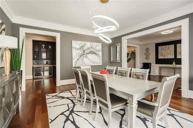 dining room with beverage cooler, crown molding, and wood finished floors