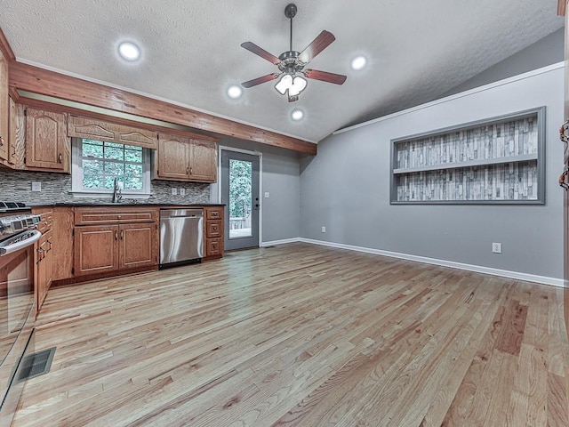 kitchen with stainless steel appliances, sink, light hardwood / wood-style floors, and vaulted ceiling