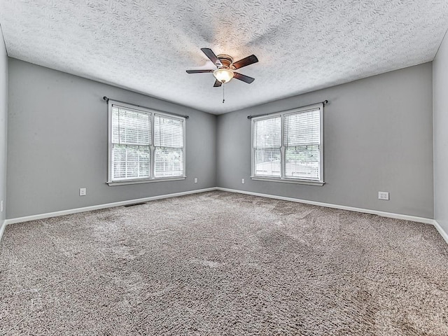 spare room with ceiling fan, a healthy amount of sunlight, carpet, and a textured ceiling