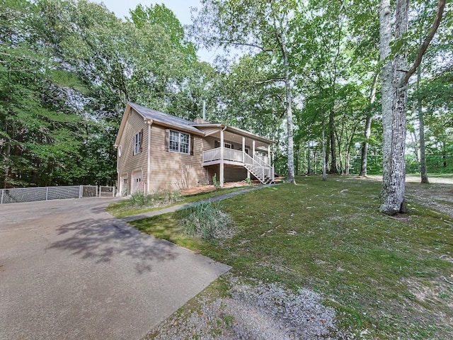 view of front of property with a garage, a front lawn, and a porch