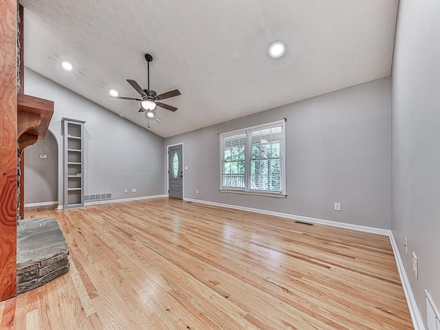 unfurnished living room featuring lofted ceiling, a textured ceiling, light hardwood / wood-style floors, and ceiling fan