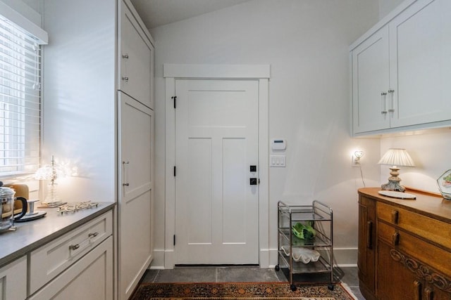 doorway to outside featuring dark tile flooring