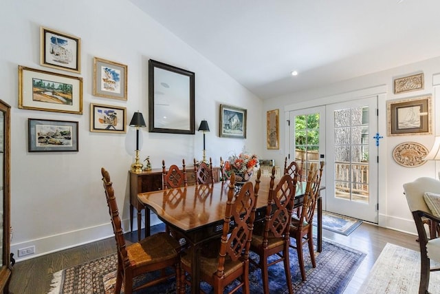 dining space featuring lofted ceiling and dark hardwood / wood-style flooring