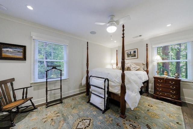 bedroom with hardwood / wood-style floors, ornamental molding, ceiling fan, and multiple windows