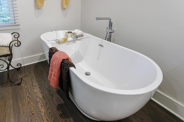 bathroom featuring a bath to relax in and hardwood / wood-style floors