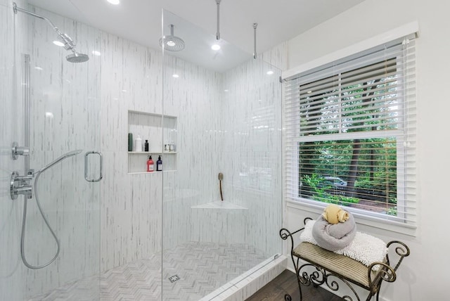 bathroom with a shower with door, a healthy amount of sunlight, and hardwood / wood-style floors