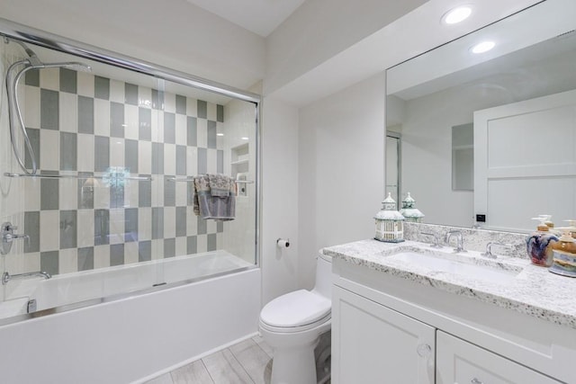 full bathroom with shower / bath combination with glass door, oversized vanity, and toilet