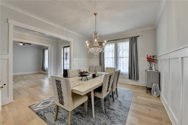 dining area with ornamental molding, a chandelier, and light wood-type flooring