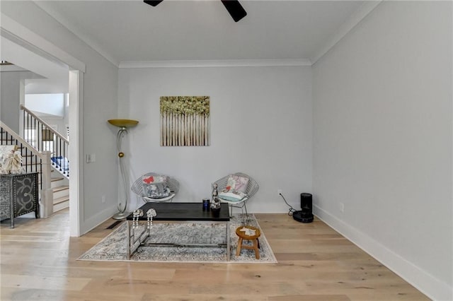 living area featuring ornamental molding, ceiling fan, and light wood-type flooring