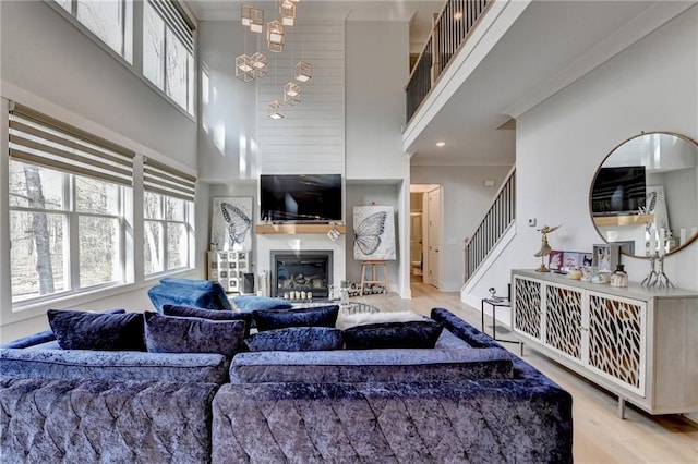 living room featuring a chandelier, a high ceiling, and light wood-type flooring