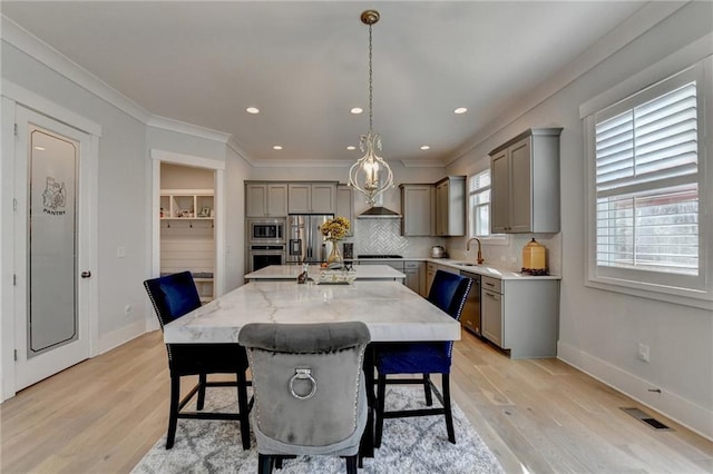 dining room with crown molding, sink, and light hardwood / wood-style flooring