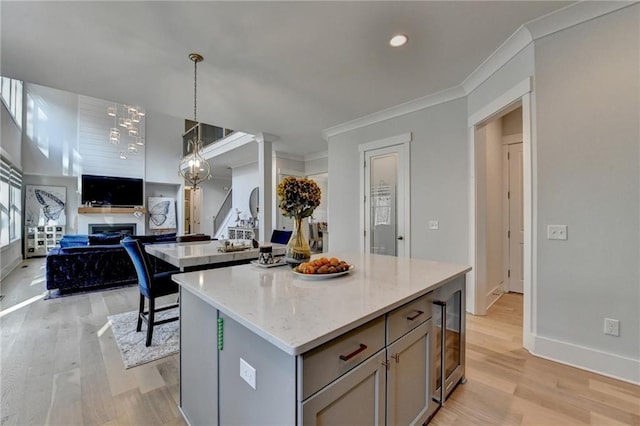 kitchen featuring gray cabinets, a center island, pendant lighting, and light hardwood / wood-style flooring