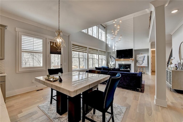 dining room featuring a high ceiling, a notable chandelier, and light hardwood / wood-style floors